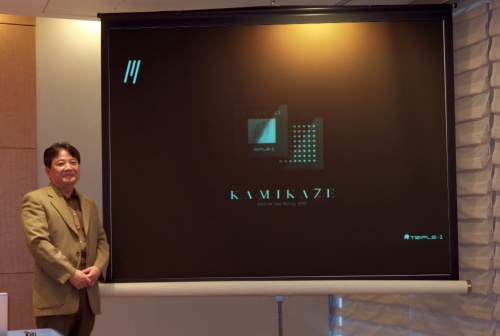 登壇した尾崎 憲一氏。日経xTECHが撮影。スクリーンはTRIPLE-1のスライド