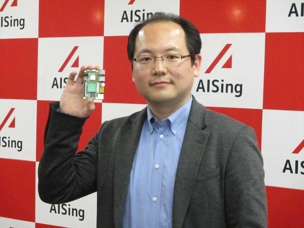 図1　エイシング代表取締役CEOの出澤純一氏　右手にあるのがAIチップ「AiiR（エアー）チップ」である。