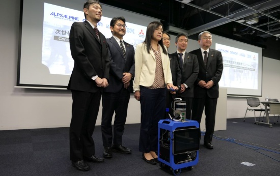 AIスーツケースの試作機と共同開発に参加する関係者。試作機に手を掛けている中央の女性は開発を主導する米IBMの浅川智恵子フェロー。