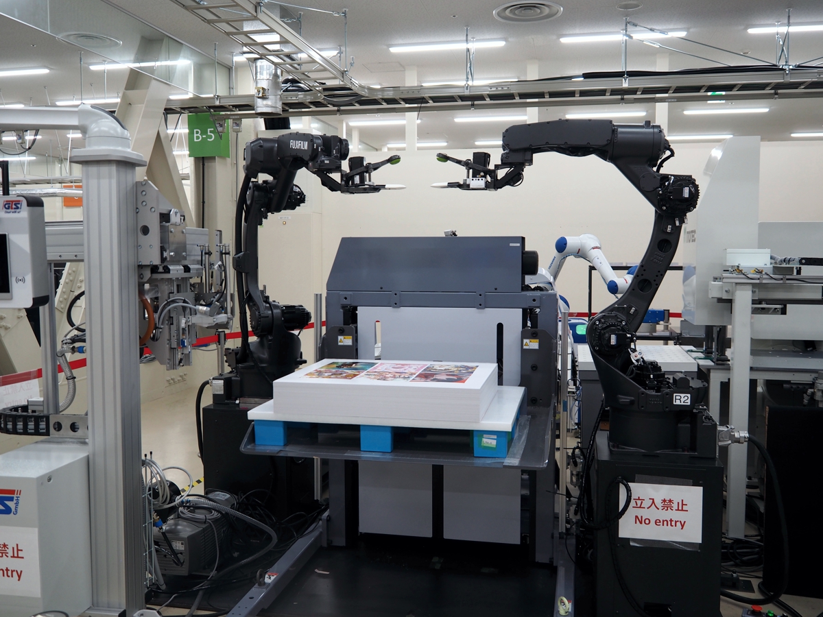 印刷工程の隙間にある重労働にスポット、双腕で紙をさばく富士フイルム