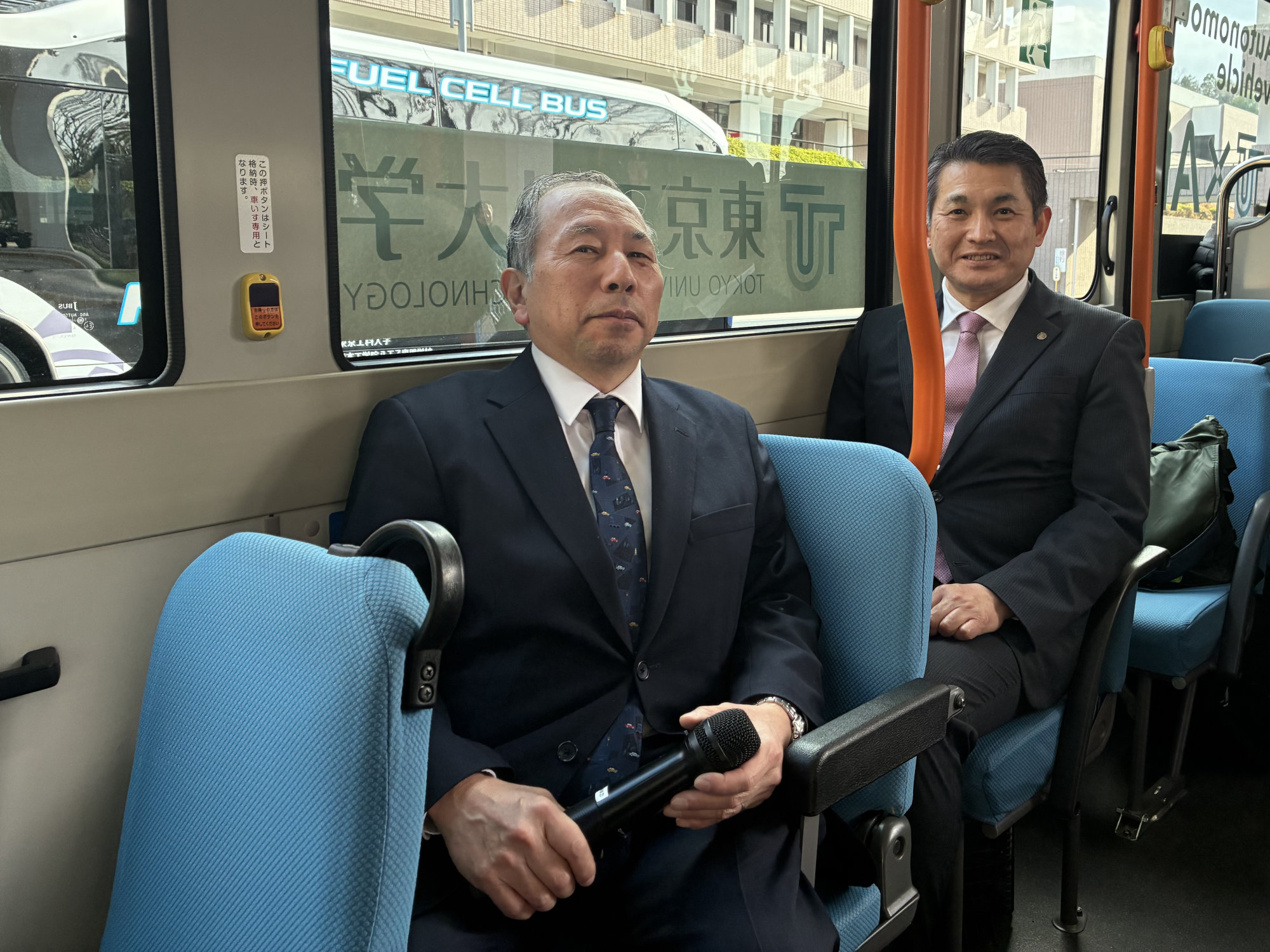 プロジェクトを主導する東京工科大学の須田氏（左）と、試乗会に参加した八王子市長の初宿和夫氏。自動運転技術によって交通インフラの充実を図りたい同市の協力も得ながらプロジェクトを進める（写真：日経クロステック）