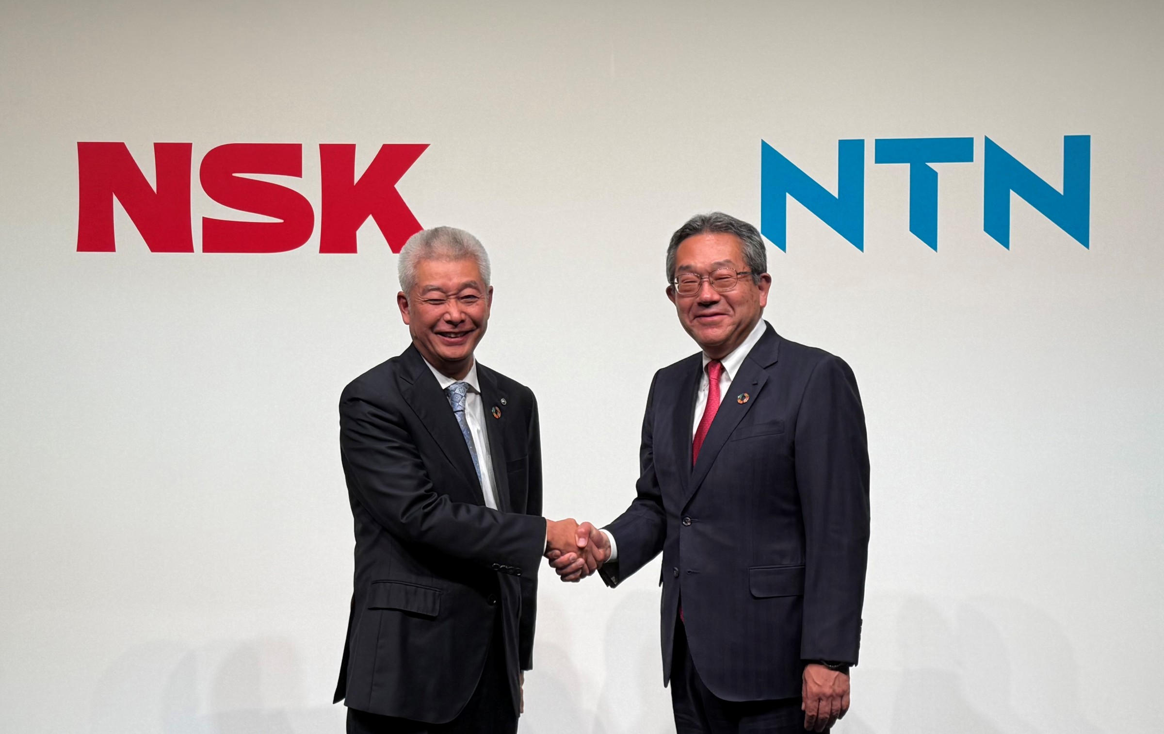 左がNSK代表執行役社長の市井明俊氏、右がNTN代表執行役執行役社長の鵜飼英一氏。両社は経営統合に向けた基本合意書を締結した（写真：日経クロステック）