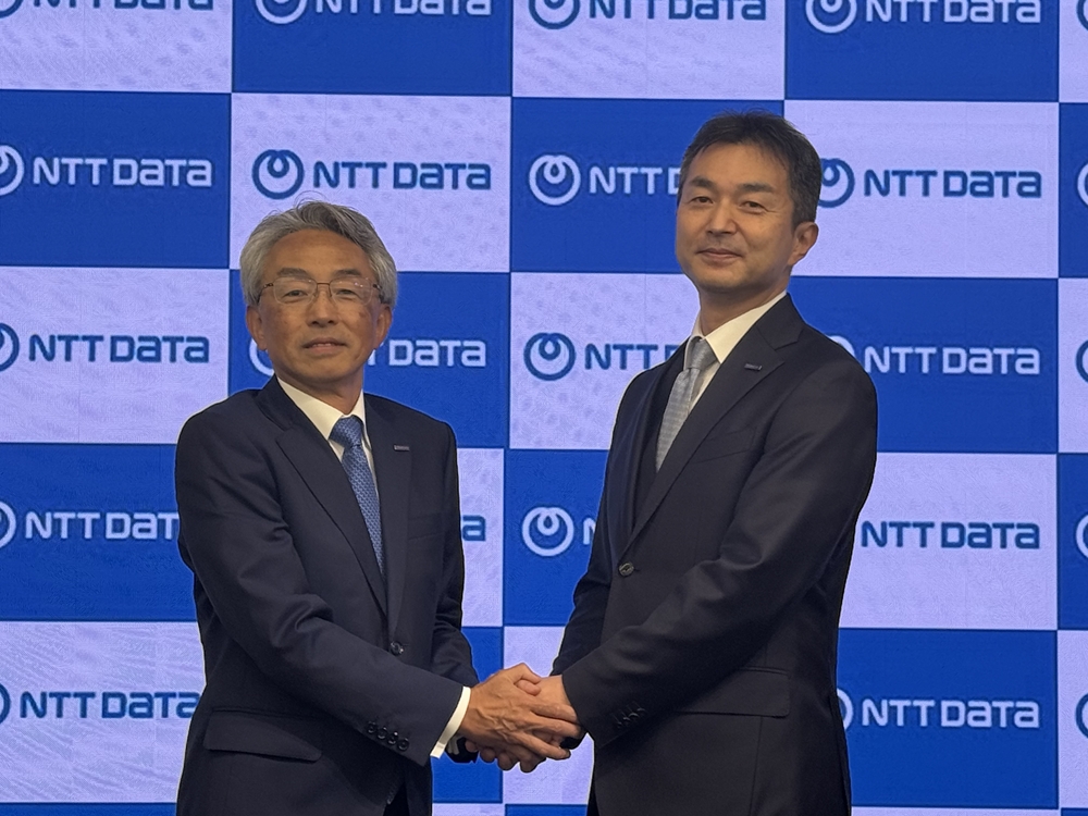 NTTデータグループの社長交代会見で握手する佐々木裕社長（左）と同社CFO（最高財務責任者）の中山和彦副社長（次期社長）