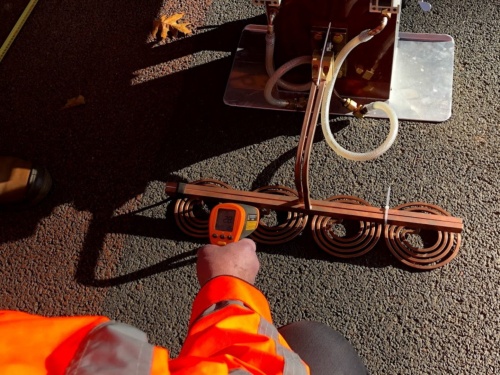 オランダで自己治癒型のアスファルト舗装を施工してから5年後に、供用状況を確認している様子。舗装表面に特殊機器を当てて加熱するだけで、劣化を修復できる(写真:山田 敏広)