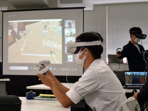 VR現場研修の会場となった東京都内の会議室の様子。受講生も講師（写真右奥）もヘッドマウントディスプレーを装着している（写真：日経クロステック）