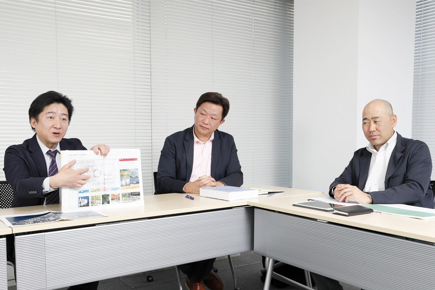 左から三井不動産レジデンシャルの高木洋一郎氏、マスターアーキテクトの一人である光井純＆アソシエーツ建築設計事務所の中野幸伸氏、ランドスケープ・マスターアーキテクトの一人である鳳コンサルタントの中野正則氏。高木氏が手にしているのが、関係者間で共有しているデザインガイドライン（写真：山田 愼二）