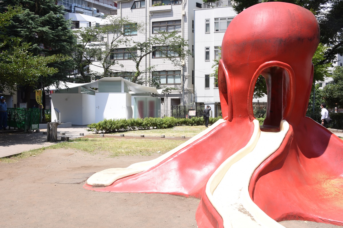 赤いタコの遊具とは対照的な、白い外観のトイレ。通称「タコ公園」に出現した「イカのトイレ」として親しまれることを槇氏は望む（写真：日本財団）