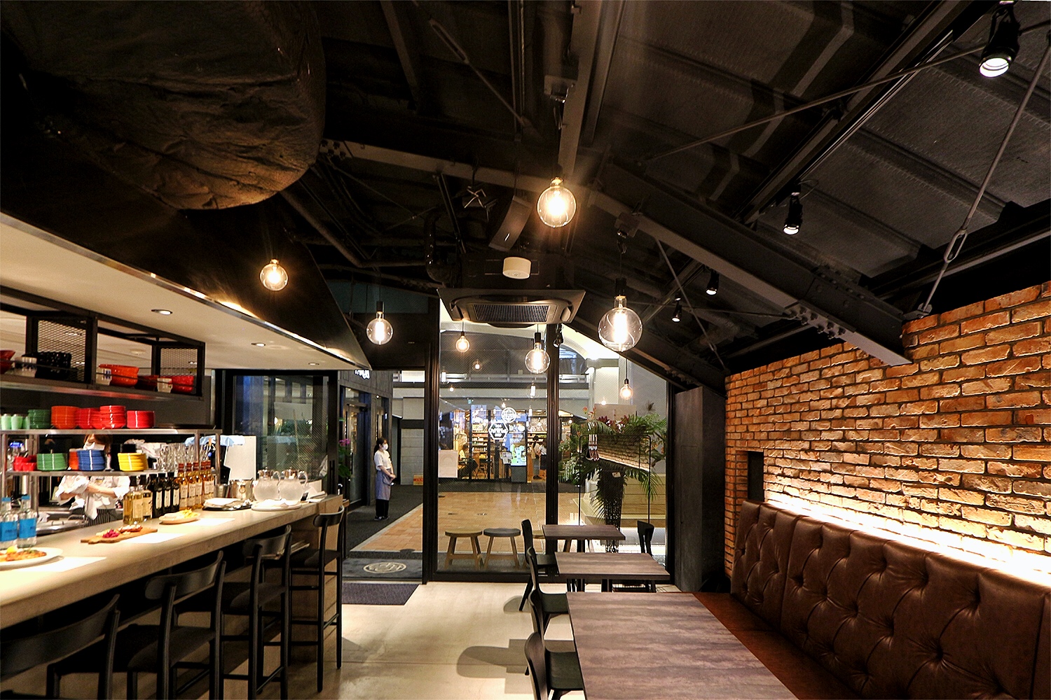 煉瓦アーチ下に入るカフェ／ダイニング「COOK BARN TOKYO」。店内から高架下通路（オープンスペース）側を見る（写真：日経クロステック）