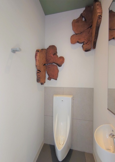 小便トイレも個室になっている。ここにも壁に木の飾りがある（写真：日経クロステック）