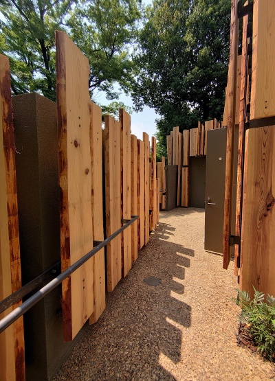 木チップを敷いて固めた小道を通って、5棟を回遊できるようにしている。突き当たりは小便トイレ。隈研吾氏は散策を楽しめるようなトイレづくりを目指したという(写真:日経クロステック)