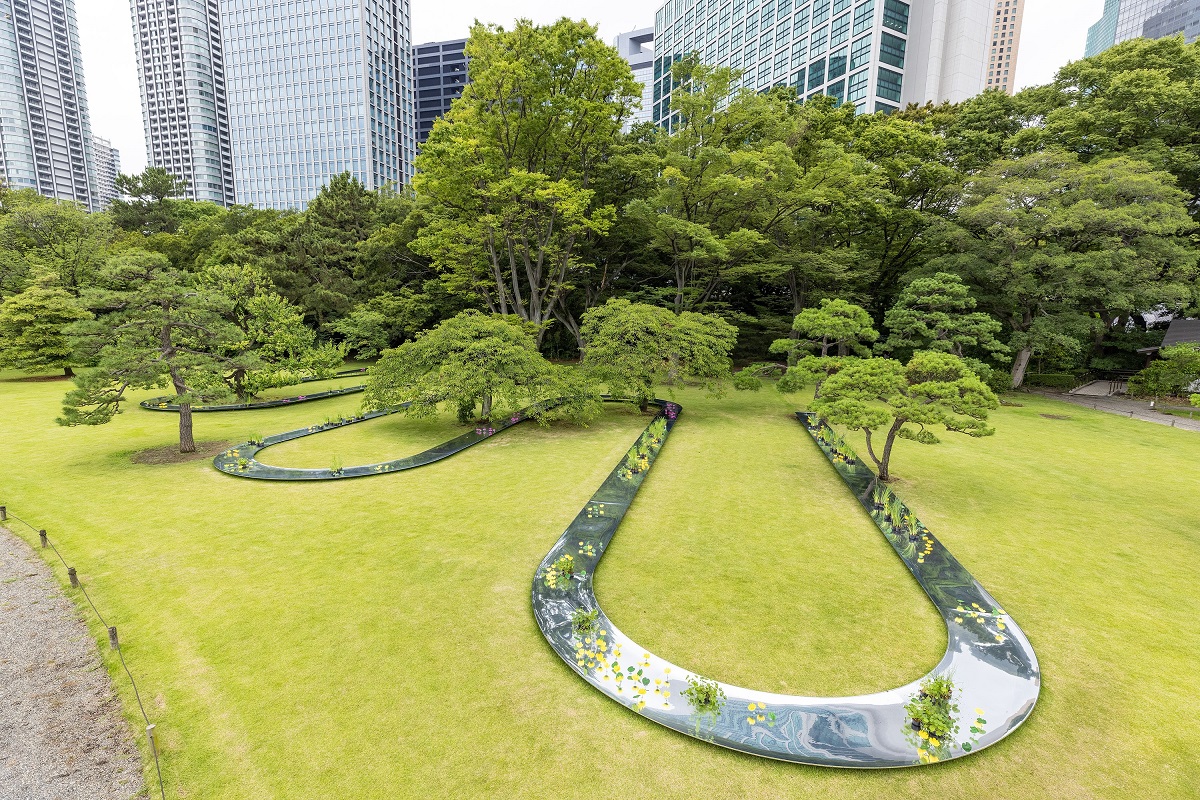 パビリオンの設置場所は、東京都中央区にある「浜離宮恩賜庭園」。写真は庭園の入り口から順路に沿って進むと、最初に目に飛び込んでくるパビリオンのある景色。写真左の通路に沿って見学する。芝生の中には入れないので、遠目に観賞することになる（写真：北山 宏一）