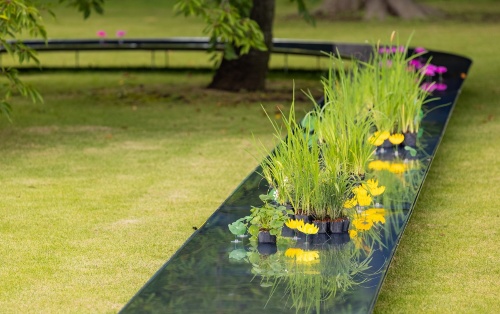 水路には造花と本物の植物を混ぜて置いた。草花の姿が水路に鏡のように映る。造花などを配置したのは、水を分岐させて流れをよくしたり、建材同士のジョイント部を隠したりする目的がある(写真:北山 宏一)