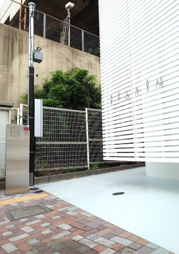 トイレの入り口は、施設の裏手(JRの線路側)にある。アルミルーバーは宙に浮いている。佐藤可士和氏がデザインしたピクトサイン以外は、公衆トイレを思わせるものが歩道からは見当たらない(写真:日経クロステック)