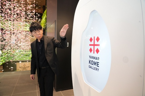 地上1階のエントランス空間に設けた「ヤンマー米ギャラリー」について説明する佐藤氏(写真:「YANMAR TOKYO」開業記念セレモニー)