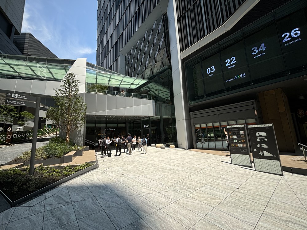 渋谷駅側の広場「SHIBUスポット」。左上の歩行者デッキで渋谷アクシュと渋谷ヒカリエをつなぐ。右上が大型ビジョンで、内覧会当日は開業までのカウントダウンを表示していた（写真：日経クロステック）