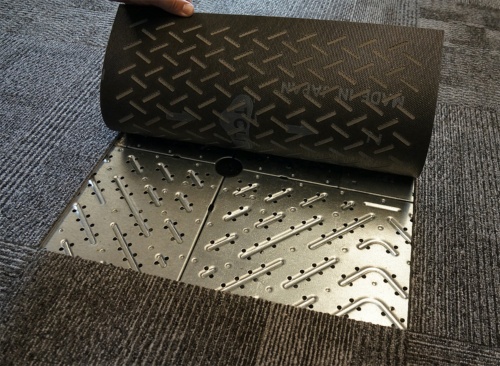 床吹き出し放射空調を採用した事務室の床。穴の空いた金属製下地板とカーペットを通して、冷暖房空気が緩やかに室内側にしみ出る（写真：守山 久子）