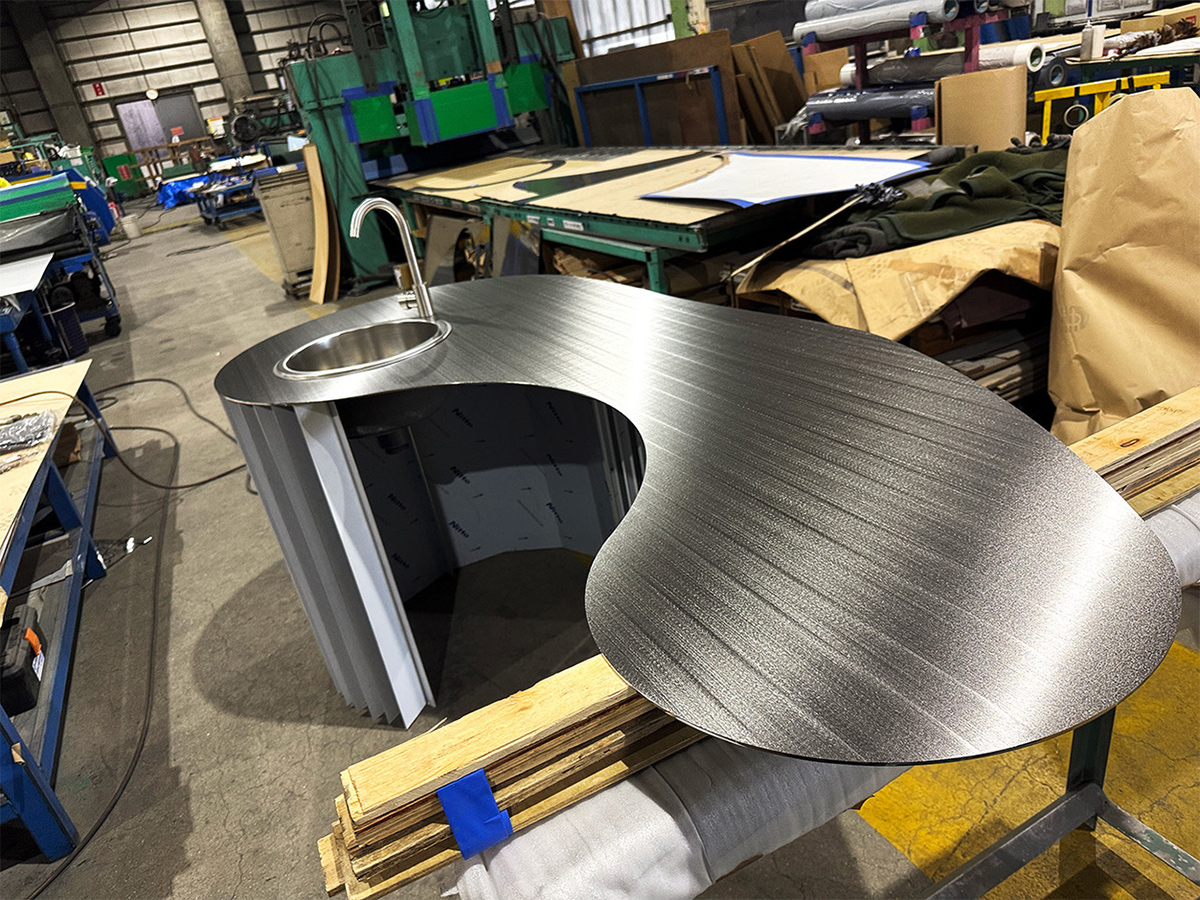 一枚板から切り出して加工するステンレスの意匠天板 | 日経クロス