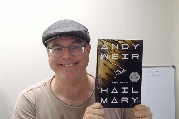 『プロジェクト・ヘイル・メアリー』を手に持つアンディ・ウィアー氏(写真:オンライン取材画面を日経クロステックがキャプチャー)