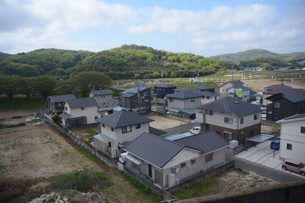 岡山県倉敷市を流れる小田川の堤防の背後に並ぶ住宅街。2018年の西日本豪雨で5mほど浸水した区域だ。2021年4月中旬に撮影（写真：日経クロステック）