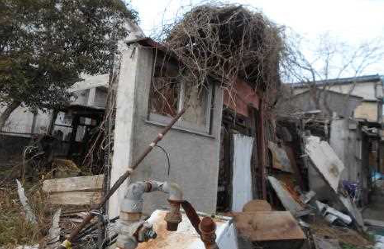 管理不全状態の所有者不明土地が周辺に悪影響を与えている例。1993年に火災が発生した後、燃え残ったがれきが放置されている（写真：国土交通省）