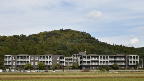 姶良市加治木町太陽光発電所の建設が進む丘を南側から遠望。麓に高齢者施設がある(写真:日経クロステック)