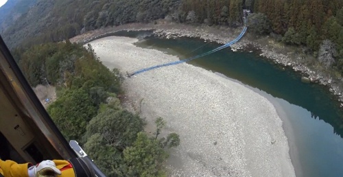 日置川の上流側から見た小房橋の崩壊状況。未撤去の木製床版と仮設の吊り足場が落下した(写真:白浜町)