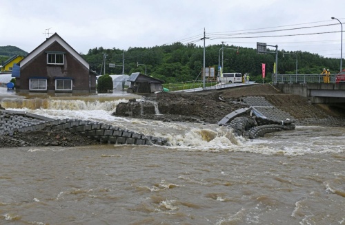 2022年6月29日のペーパン川氾濫による浸水被害の様子。仮締め切りを越えた水が新河道内を通って農地などに広がった。写真は、農地などに広がった水が、再び河川内に流入している状況（写真：共同通信社）