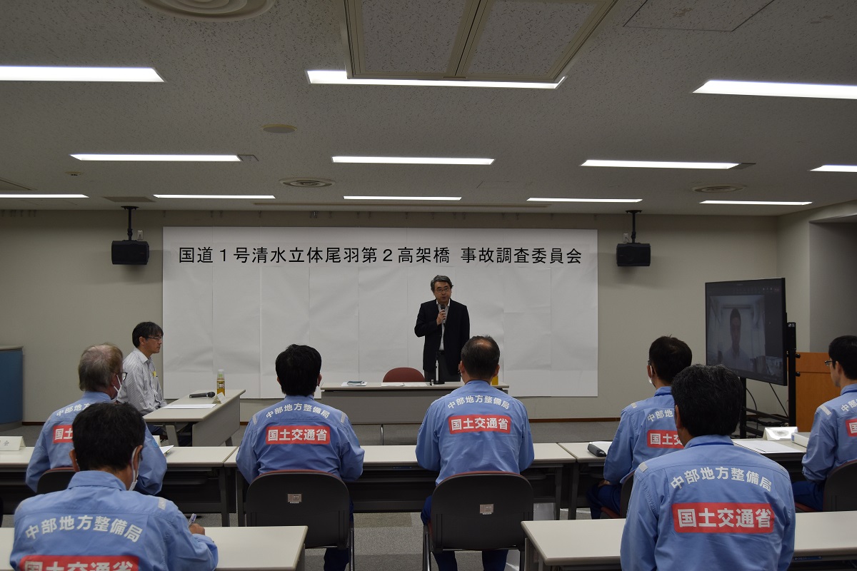 「国道1号清水立体尾羽第2高架橋事故調査委員会」の初会合に出席した委員。中央が名古屋大学大学院工学研究科の舘石和雄教授、左は国土交通省国土技術政策総合研究所橋梁研究室の白戸真大室長。右のモニターにはオンラインで参加した大阪大学社会基盤工学講座構造工学領域の廣畑幹人准教授が映っている（写真：日経クロステック）