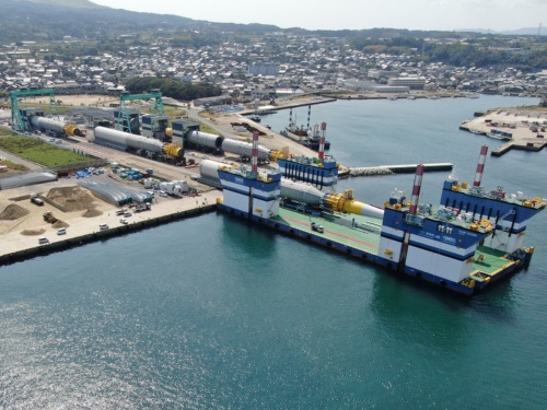 設置海域まで海上運搬するため、岸壁で組み立てた浮体部を台船に積載する様子（写真：戸田建設）