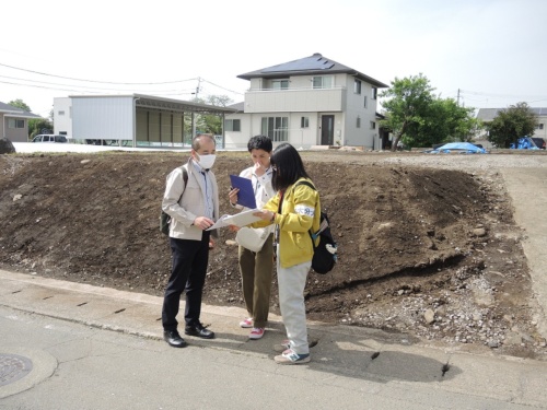 学生たちが現地で調査している様子。左側は京都大学の五十田博教授。調査エリアには被災した住宅や擁壁を撤去して、更地になっている敷地が目立つ（写真：日経 xTECH）
