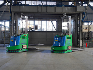 階をまたいだ資材搬送を自動化、ロボの働きぶりはAIが監視・支援