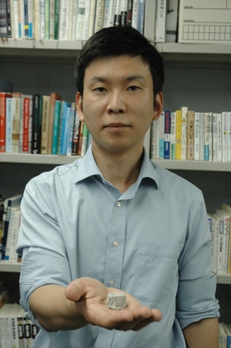 砂同士を接着した硬化体を持つ東京大学生産技術研究所の酒井雄也准教授(写真:日経クロステック)