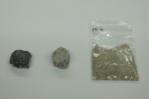 ケイ砂から製造した硬化体(左の2つ)と原料のケイ砂。通常の方法で製造した硬化体(中央)に加えて、加熱して強度を高めた硬化体(左)を製造した(写真:日経クロステック)