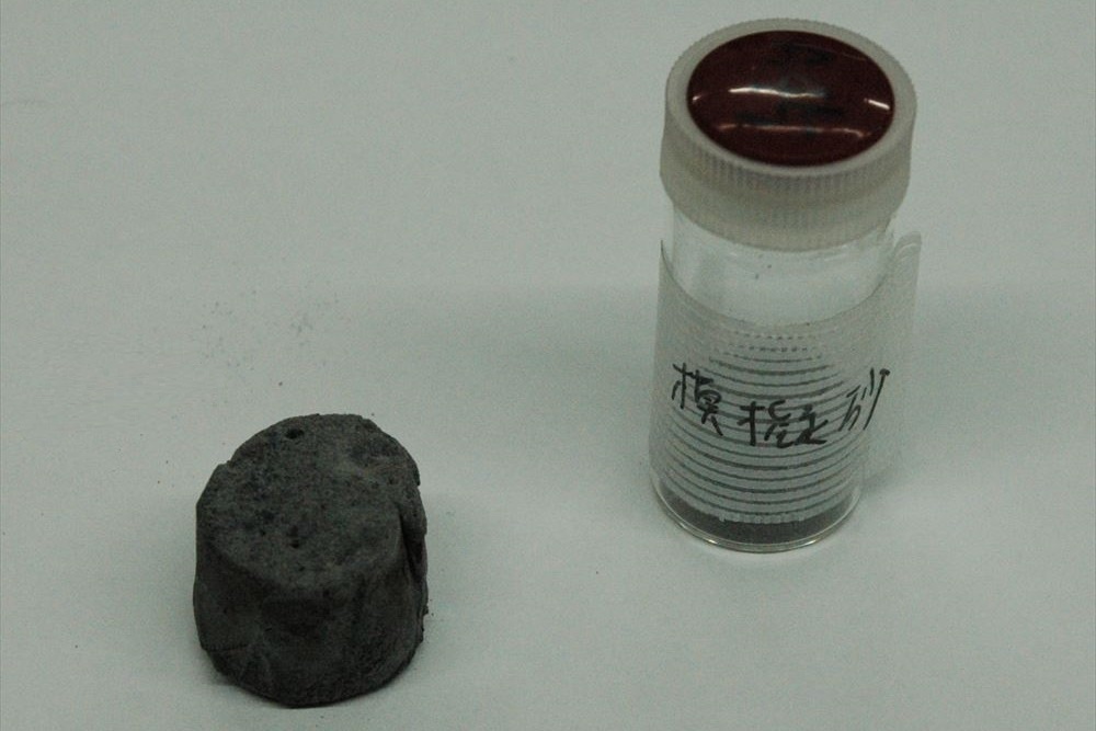 月の模擬砂から製造した硬化体と原料の月の模擬砂。模擬砂はニチレキから提供された（写真：日経クロステック）