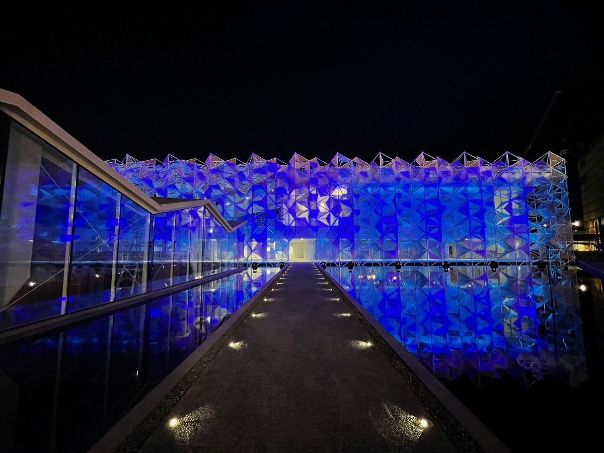 青くライトアップした日本館。夜も水盤にファサードが映り込み、建物が実物よりも大きく見える（写真：永山祐子建築設計）
