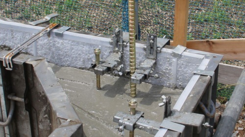 鋼製型枠の立ち上がりの内側にMパネルを取り付けた状態で、コンクリートを打設している様子（写真：日経クロステック）