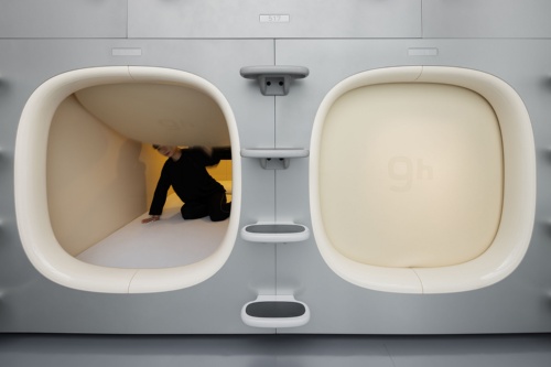 カプセルホテル「ナインアワーズ大手町」で、新型カプセルに取り付けた遮音ハッチを開閉している様子(写真:Nacasa & Partners)