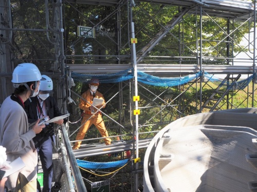 公開日の様子。オレンジ色の作業服で説明するのは、大林組技術本部技術研究所生産技術研究部の金子智弥担当部長(写真:日経クロステック)