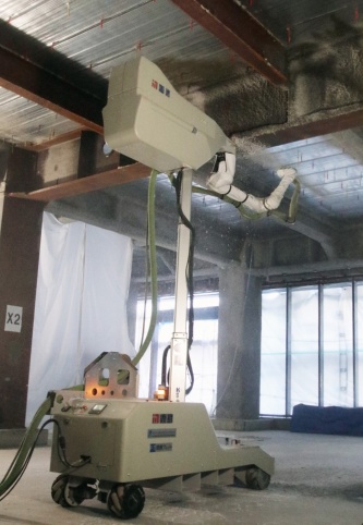 耐火被覆吹き付けロボットの最新型。3次元レーザースキャナーで梁部材を認識し、形状に応じてロボットアームを動かす。人による作業よりも吐出量を増やせるので、スピーディーに被覆できる。具体的な歩掛かりは今後、精査する（写真：日経クロステック）