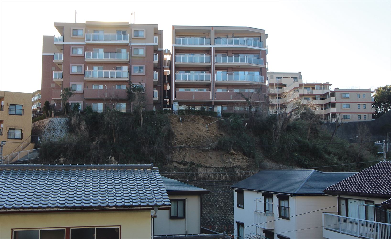 2020年2月5日に敷地内の斜面が崩落して通行人が死亡した神奈川県逗子市内の分譲マンション「ライオンズグローベル逗子の丘」。60トン以上の土砂が崩れた。写真は事故翌日の様子（写真：日経クロステック）