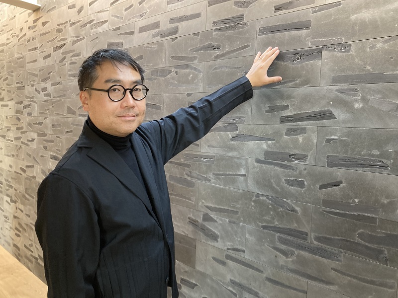 柑炭を配合した建材用ブロックを開発したASEI建築設計事務所の鈴木亜生氏。炭のフィルター効果を生かした外装材による水の浄化と、内装材としての吸放湿性や空気清浄効果を期待する（写真：有岡 三恵）