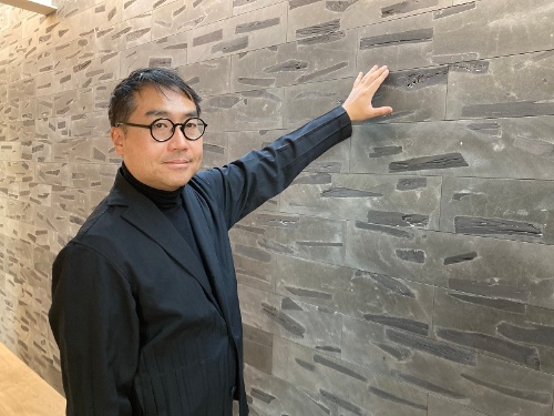 柑炭を配合した建材用ブロックを開発したASEI建築設計事務所の鈴木亜生氏。炭のフィルター効果を生かした外装材による水の浄化と、内装材としての吸放湿性や空気清浄効果を期待する(写真:有岡 三恵)