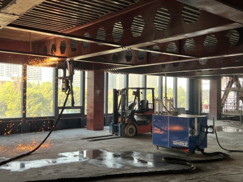 プラズマ切断ロボットで鉄骨梁に切り込みを入れる。ロボットは搭載したレーザーセンサーによる位置情報を使って制御する。切り込み作業中は人手が不要だ(写真:清水建設)