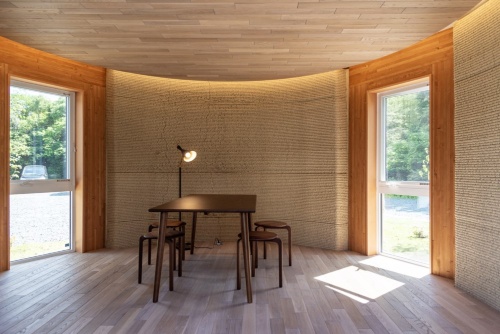 建物の内部には、木や土などの自然素材に囲まれた空間が広がっている(写真:日経クロステック)