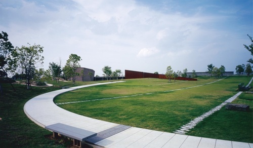 大分県中津市にある火葬施設「風の丘葬斎場」。建物は葬斎場ホール、葬斎場の待合棟、炉室のある火葬棟の3つから成る。ランドスケープと一体になった建物だ(写真:吉田 誠)