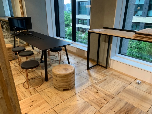 床に敷き詰めた新建材「WOOD FLOOR UNIT 3.2(仮称)」。表面を触ると木の質感が残っているように感じた(写真:日経クロステック)
