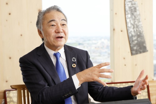 AQ Groupの宮沢俊哉社長。中学校卒業と同時に大工の道に進み、1978年にAQ Groupの前身企業を創業。近年は中規模木造の普及に奔走する(写真:山田 慎二)