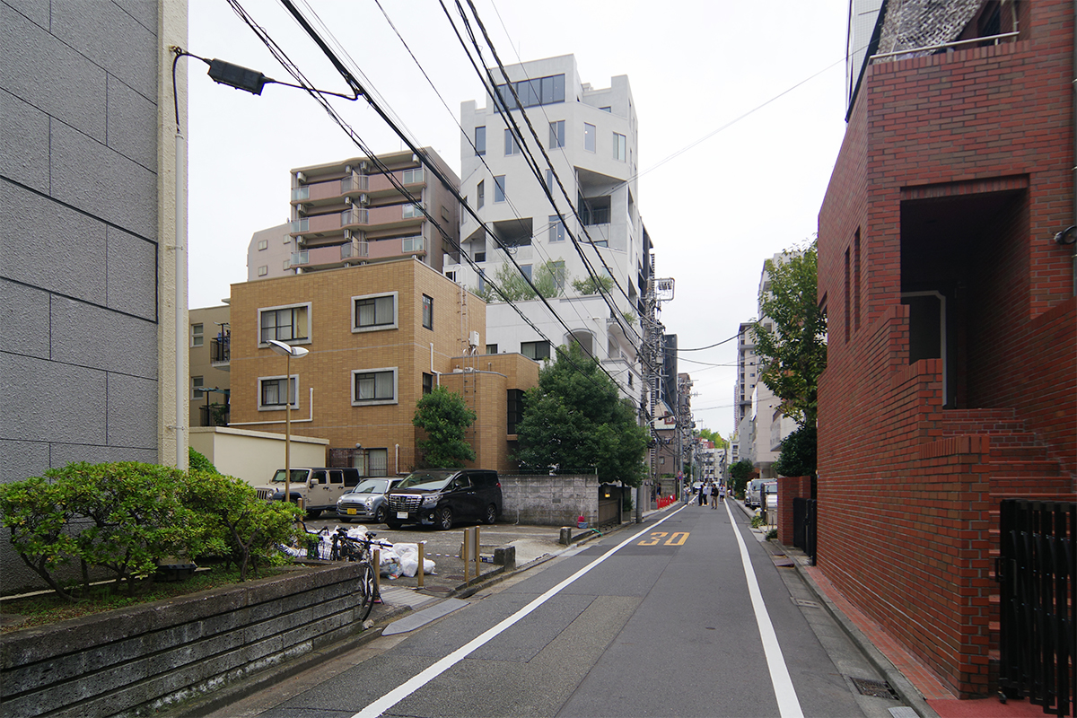 中央の白く背の高い建物がhanaqumoi。よくある直方体の建物が立ち並ぶ中、四隅を斜めに切り欠いて大きな開口を設けたマンションは存在感がある（写真：日経クロステック）