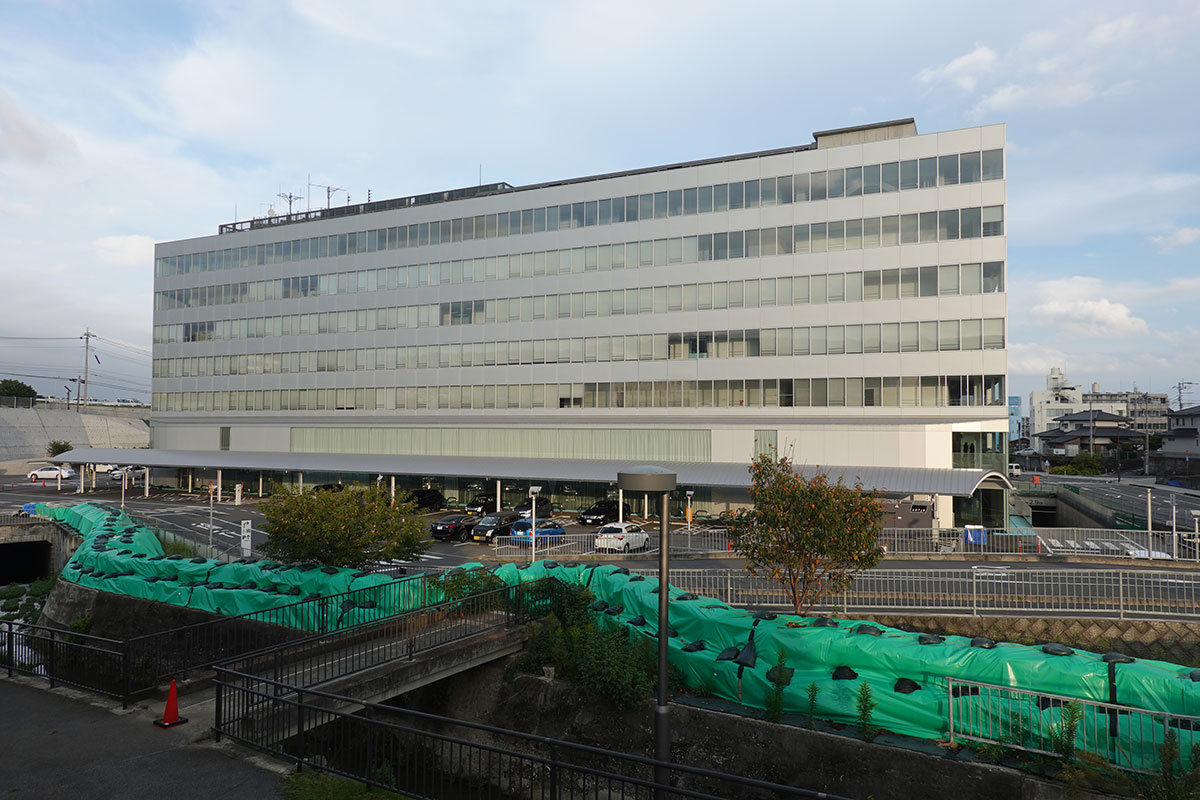 越水した河川側から日立市庁舎の現在の様子をのぞむ。数沢川沿いに仮設の堤を設置している。2024年10月に撮影（写真：日経クロステック）