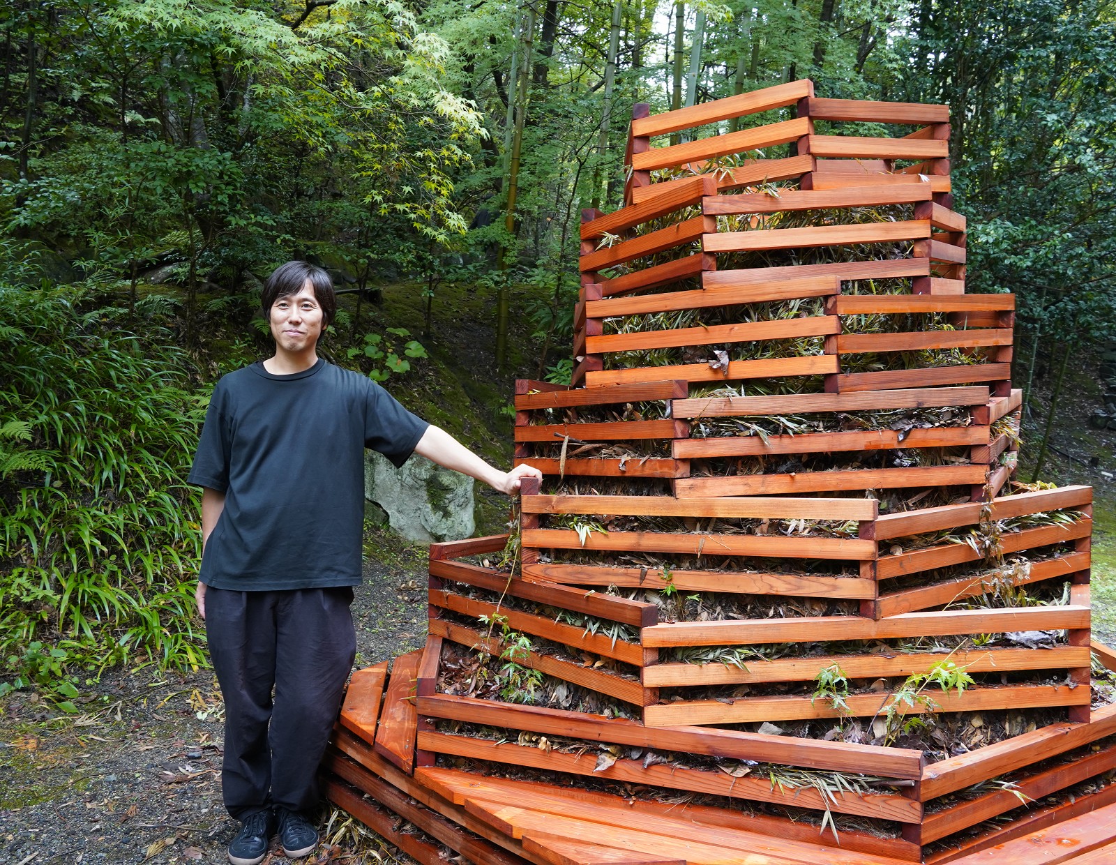 川島範久建築設計事務所の川島範久氏（左）と、神勝寺の敷地内に設置した「コンポスト」（右）。落ち葉や枝を集めて堆肥にする（写真：日経クロステック）